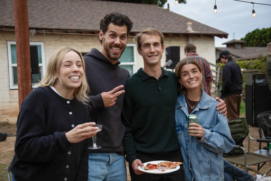 Four friends with drinks at a backyard party
