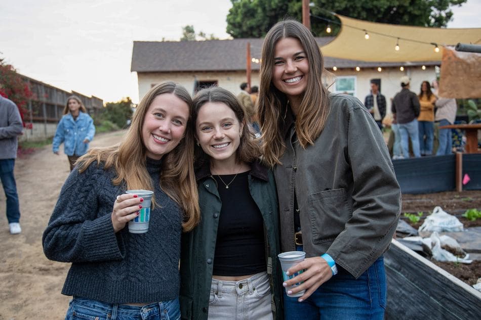 Three friends with drinks at golden hour