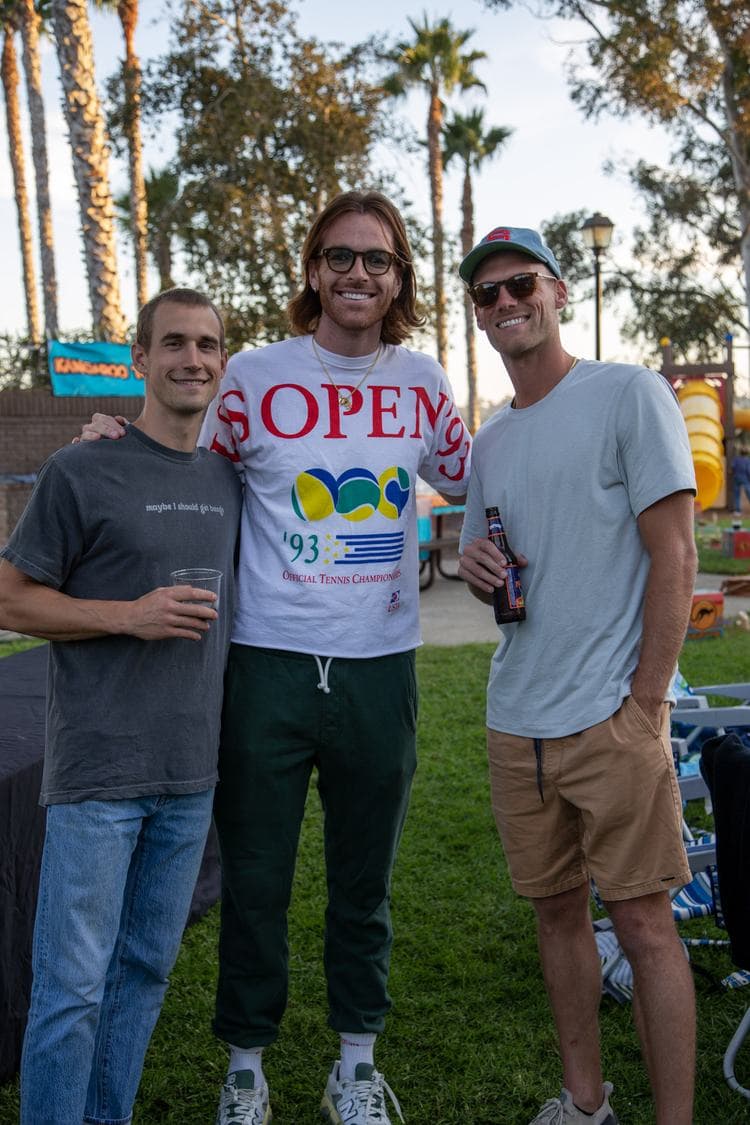 Three friends with drinks on the grass