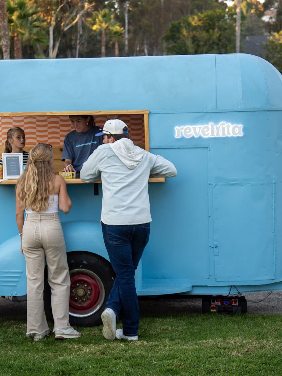Guests ordering drinks at the cart window at a party