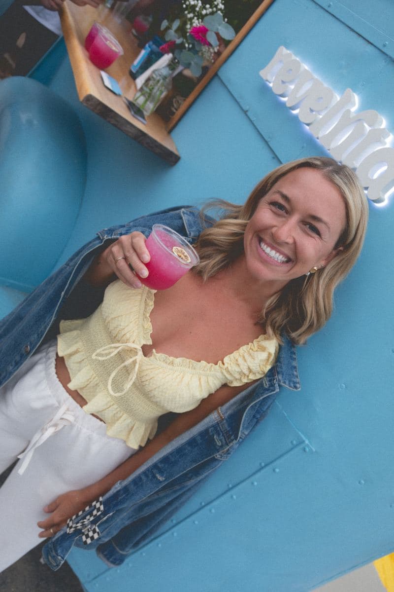 A guest raising a pink margarita against the cart