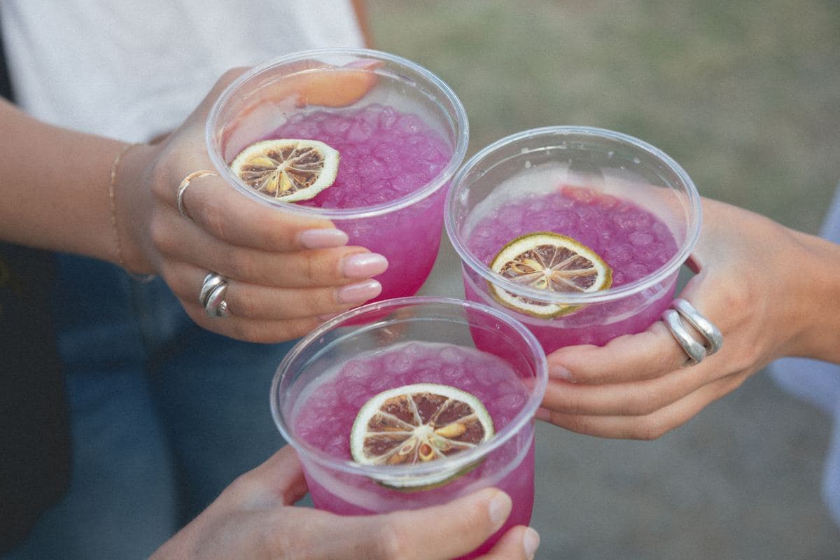 Three pink margaritas raised for a cheers