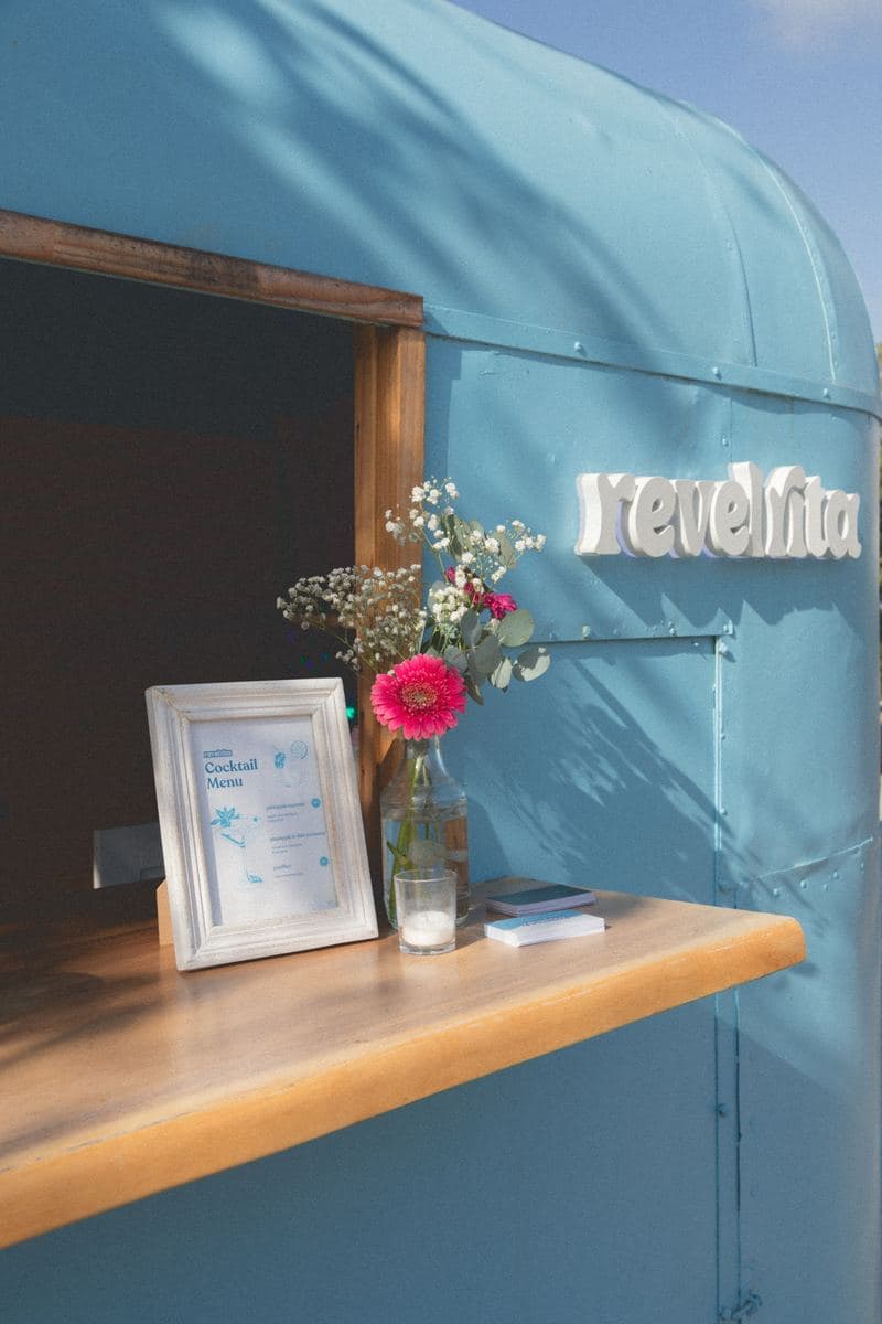The cart window with the cocktail menu and fresh flowers